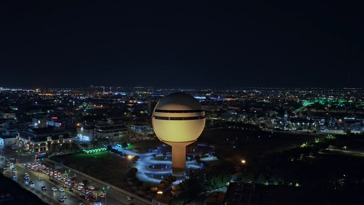 برج مياه بريدة مضاء ليلاً، لقطة جوية.