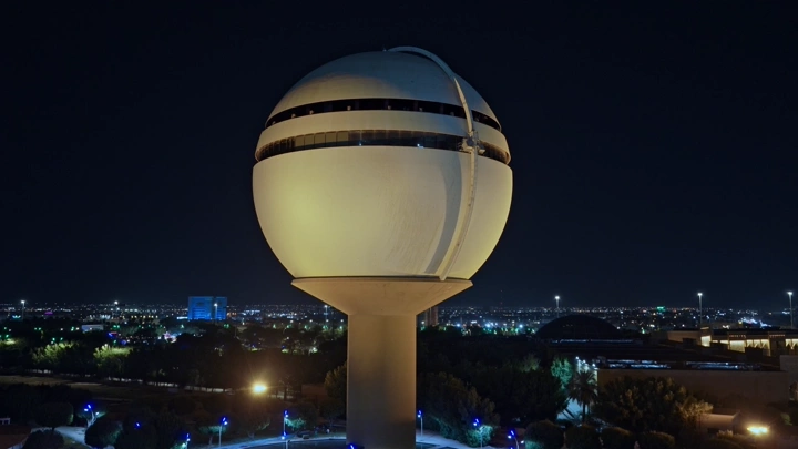 برج مياه بريدة مضاء ليلاً، لقطة جوية.