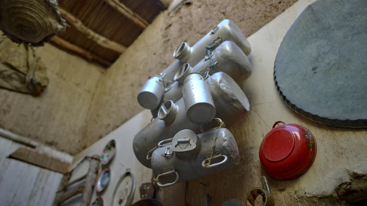 أواني معدنية قديمة معلقة في متحف تراثي، لقطة داخلية.