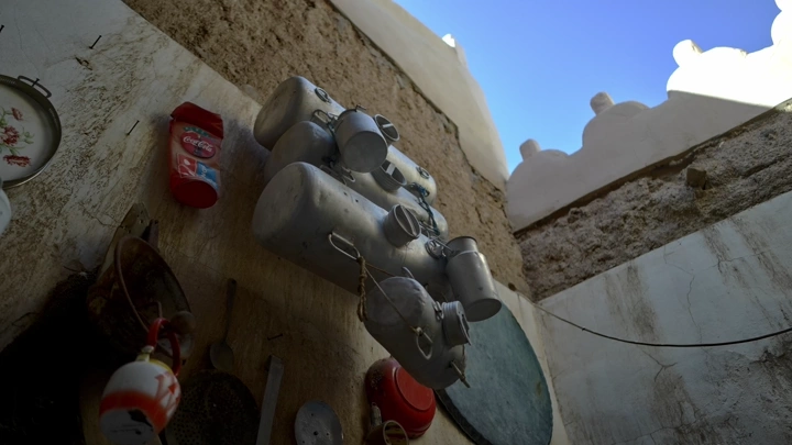 أدوات مطبخ تقليدية معلقة في متحف، لقطة بزاوية منخفضة.