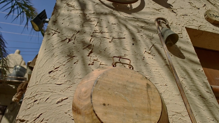 أدوات تقليدية معلقة على جدار متحف في ضوء الشمس، لقطة قريبة.