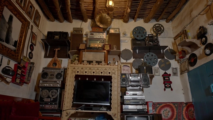 غرفة معيشة قديمة مليئة بأجهزة إلكترونية قديمة، لقطة داخلية.