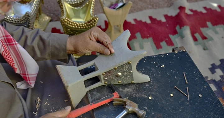 حرفي يصنع مبخرة تقليدية على طاولة عمل، لقطة مقربة.