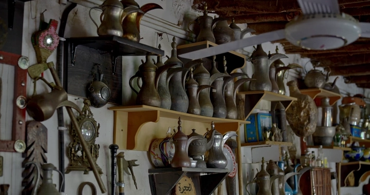 مجموعة من الدلال القديمة على رفوف في متحف، لقطة داخلية.