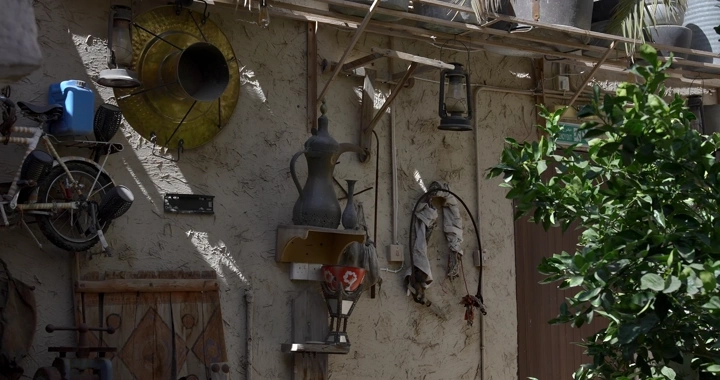 مجموعة من الأدوات القديمة معلقة على جدار متحف في الهواء الطلق، لقطة نهارية.