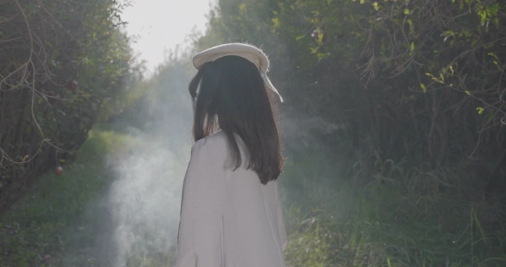 فتاة في مزرعة رمان، لقطة خلفية.