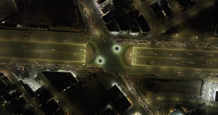 تقاطع طرق مضاء في حائل ليلاً، لقطة جوية.