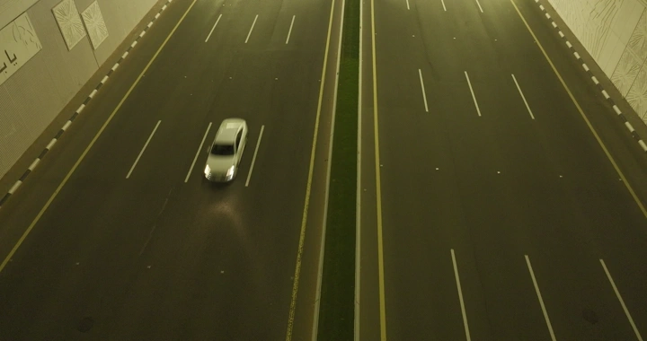 سيارة تسير في نفق بمدينة حائل، لقطة علوية ليلية.