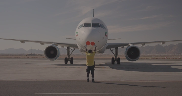 طائرة تهبط في مطار مع مرشد أرضي، لقطة أمامية.