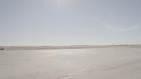 طيارة تقلع من مدرج مطار تحت سماء صافية، لقطة نهارية.