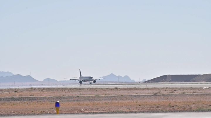 طائرة تقلع من مدرج في مطار، لقطة بعيدة.