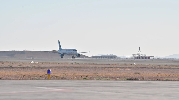 طائرة تستعد للإقلاع في مطار، لقطة بعيدة.