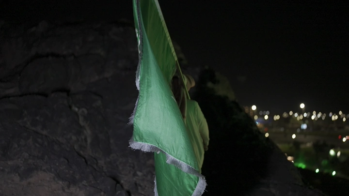 علم السعودية على جبل ليلاً، تصوير ليلي.