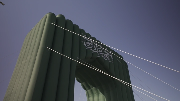 قوس يحمل علم السعودية في حائل بمناسبة اليوم الوطني السعودي، لقطة من الأسفل.