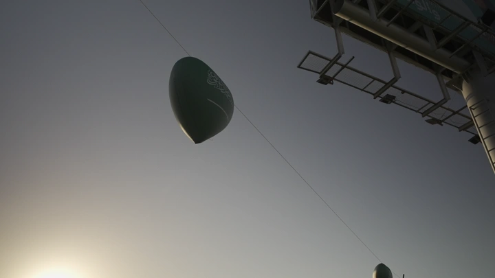 بالون أخضر في السماء خلال اليوم الوطني السعودي في حائل، لقطة من الأسفل.