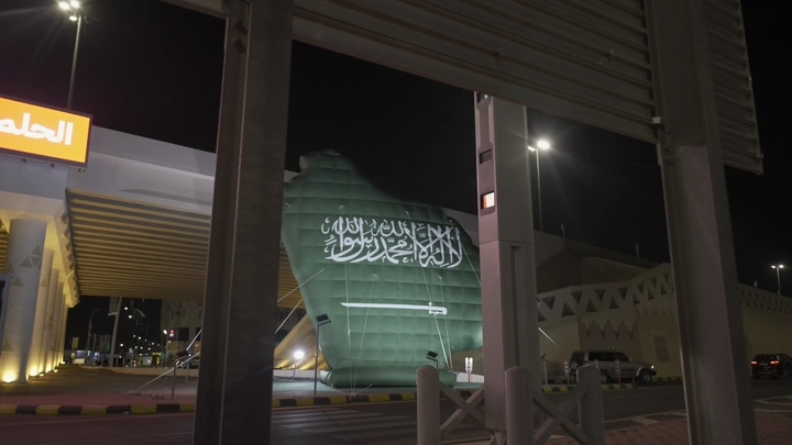 علم سعودي مضاء في الليل في حائل، لقطة ليلية.