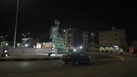 دوار في حائل ليلاً مع إضاءة المباني والسيارات، لقطة ليلية.