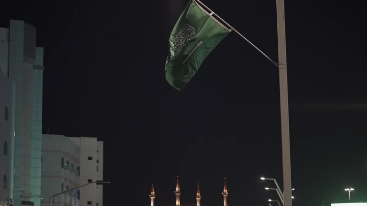 علم السعودية يرفرف في الليل، تصوير ليلي.
