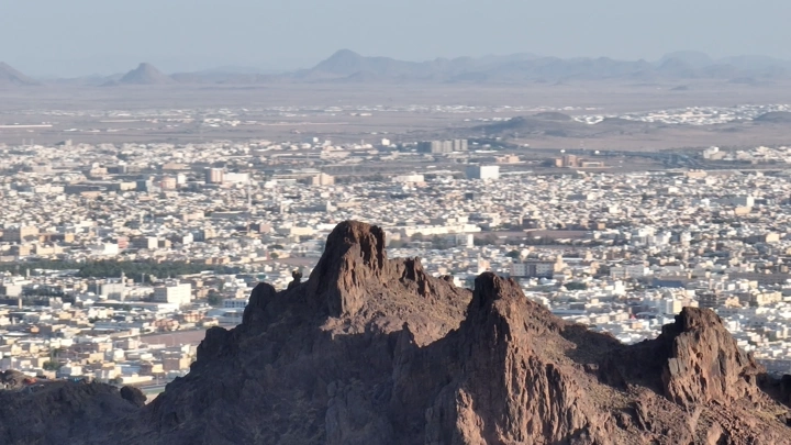 جبل المغواة في حائل مع المدينة في الخلفية، لقطة جوية.