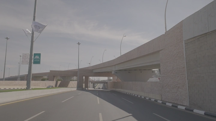 طريق سريع تحت جسر في وضح النهار، لقطة واسعة.
