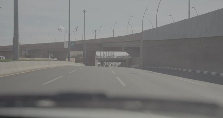 طريق سريع تحت جسر في حائل في وضح النهار، لقطة من داخل سيارة.