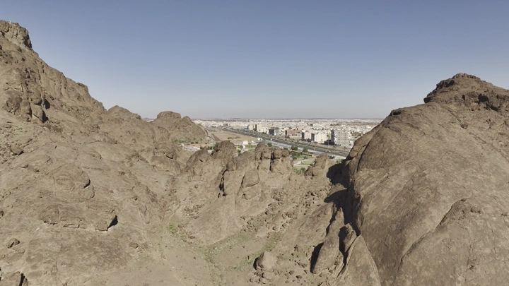 جبال صخرية تطل على مدينة حائل، لقطة جوية.