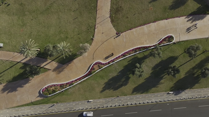 لقطة جوية لحديقة الأمير سعود بن عبدالمحسن في حائل، تُظهر ممرات وأشجار.