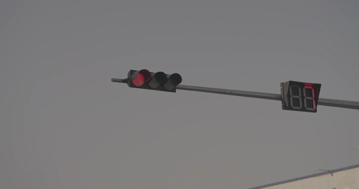 إشارة مرور حمراء مع عداد تنازلي في النهار، لقطة من الأسفل.