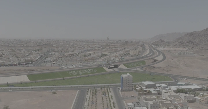 طريق دائري في حائل مع مباني وجبال، لقطة درون.