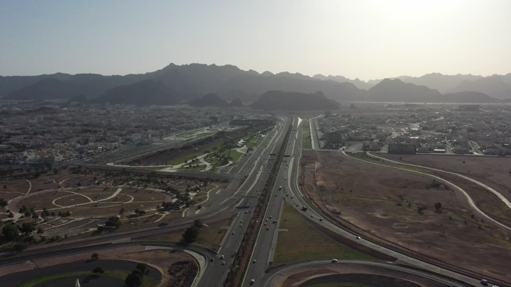 طريق دائري في حائل مع الجبال في الخلفية، لقطة درون.