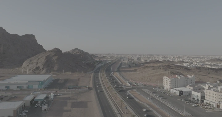 طريق دائري في حائل مع الجبال والمباني، لقطة درون.