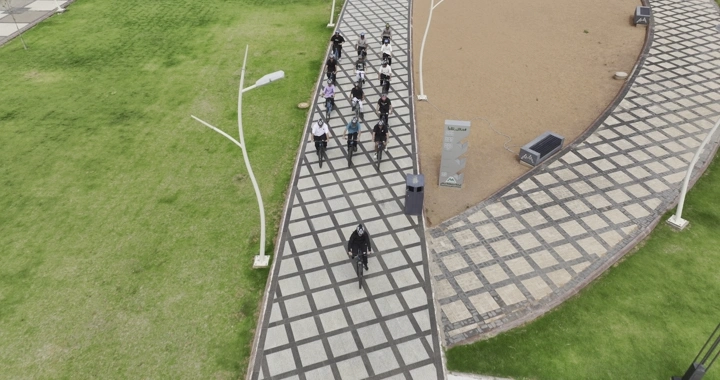 مجموعة دراجين على مسار مرصوف في حائل، لقطة من الجو.