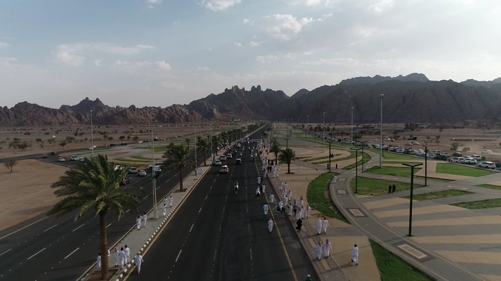 موكب في طريق مفتوح مع جبال في الخلفية في حائل، لقطة جوية.