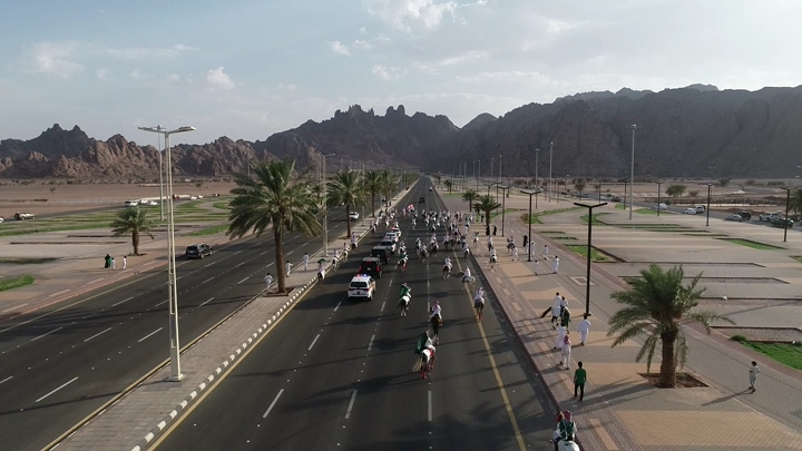 موكب خيول على طريق طويل خلال اليوم الوطني في حائل، لقطة جوية.