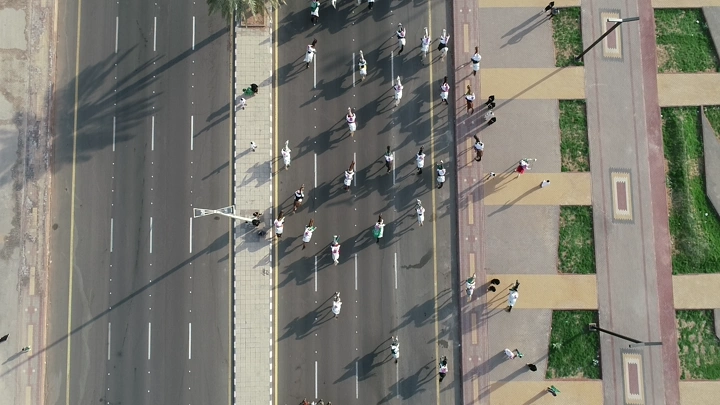 مسيرة في شارع للاحتفال باليوم الوطني في حائل، لقطة جوية.