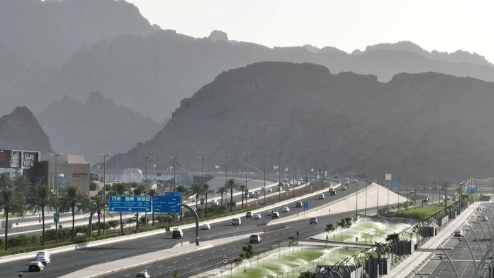 طريق سريع في حائل مع جبال في الخلفية، لقطة من الأعلى.