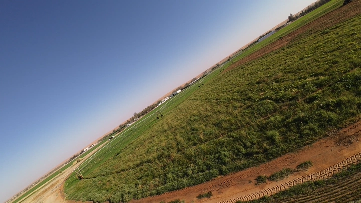 مزرعة خضراء مع محراث، لقطة جوية مائلة.