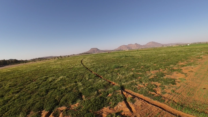 مزرعة خضراء واسعة مع محراث، لقطة جوية.