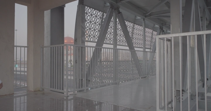 رجل يمشي على جسر مشاة حديث، لقطة نهارية.