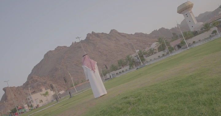 رجل في حديقة حائل أمام جبل، لقطة واسعة.