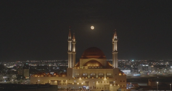 مسجد الراجحي مضاء تحت ضوء القمر في حائل، تصوير ليلي.