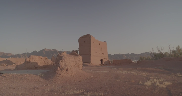 بيت طيني في الصحراء عند الغروب، لقطة واسعة.
