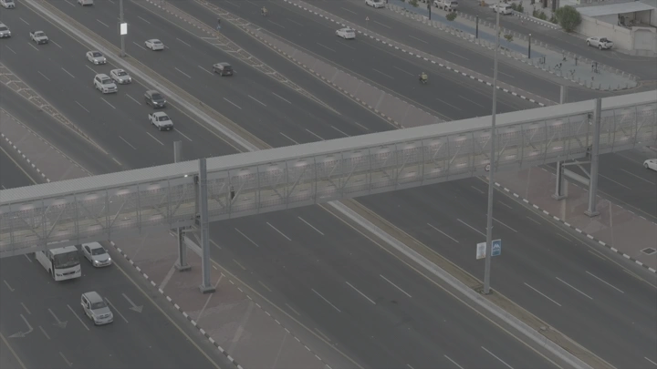 جسر مشاة فوق طريق سريع مزدحم، لقطة من الأعلى.