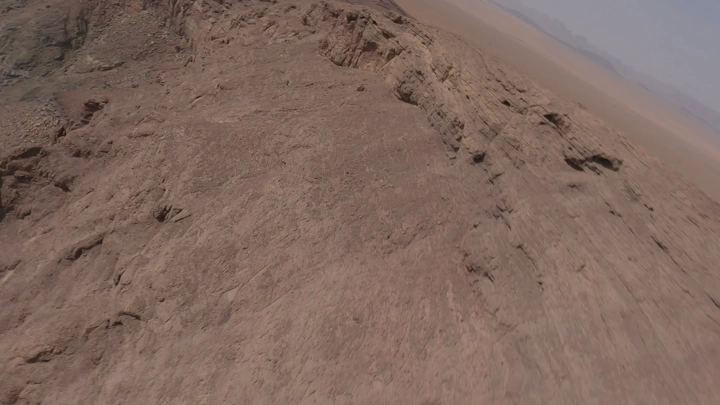 شخص يمشي على حافة فوهة بركان الهتيمه في حائل، لقطة جوية.