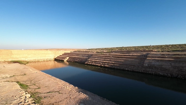 بركة عين زبيدة الأثرية تحت السماء الزرقاء، لقطة واسعة.