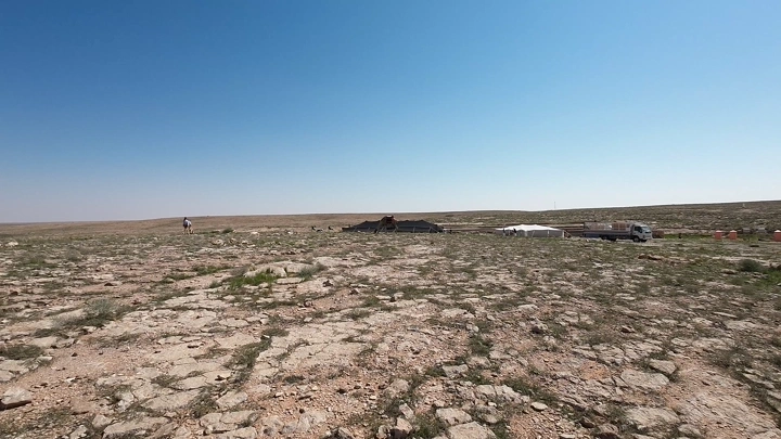 صحراء مع خيام وجمال، لقطة نهارية واسعة.