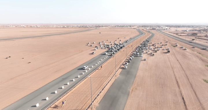 سباق هجن في الصحراء مع سيارات مرافقة، لقطة جوية.