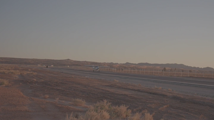 طائرة خاصة على مدرج في منطقة صحراوية، لقطة من الأرض.