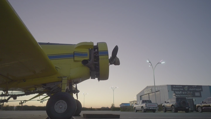 طائرة صفراء في مطار خاص عند الغروب، لقطة جانبية.