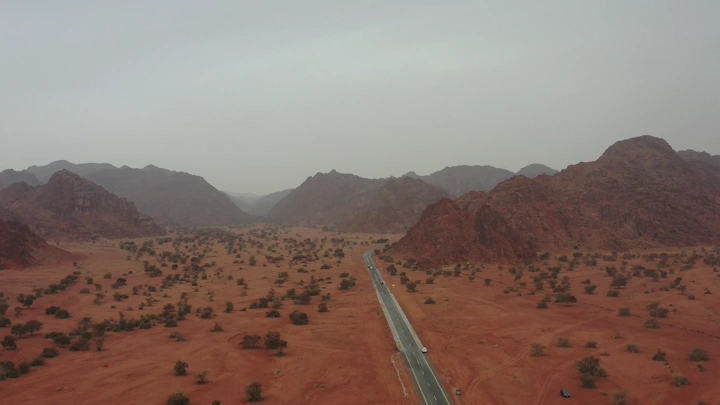 طريق في صحراء جو حائل مع جبال في الأفق، لقطة جوية.